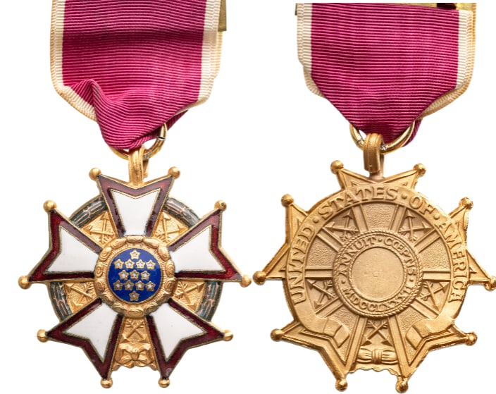 Legion of Merit, Legionnaire, instituted in 1942: Breast Badge, 51x48 mm., gilt Bronze, one side enameled, on a wreath of green laurel joined at the bottom by a gold bow-knot (rosette), a five-pointed white star bordered crimson, points reversed