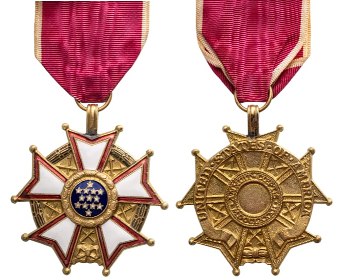 Legion of Merit, Legionnaire, instituted in 1942: Breast Badge, 52x47 mm., gilt Bronze, one side enameled, on a wreath of green laurel joined at the bottom by a gold bow-knot (rosette), a five-pointed white star bordered crimson, points reversed