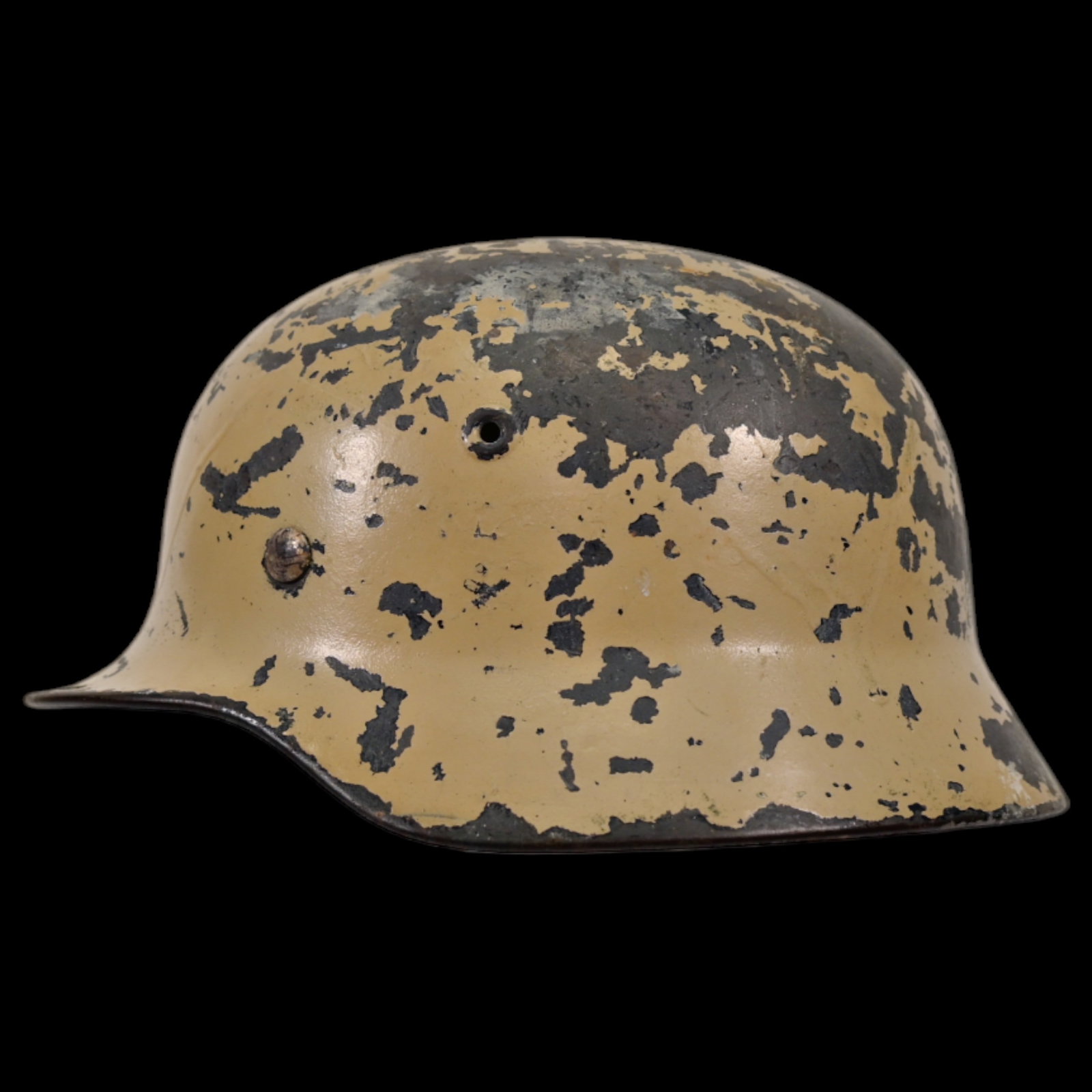 WWII Nazi German M40 Combat Helmet featuring original tan camouflage.: WWII Nazi German M40 Combat Helmet featuring original tan camouflage. The M40 model is known for its rolled edge and stamped air vents, with this particular helmet showing remnants of its winter camo,