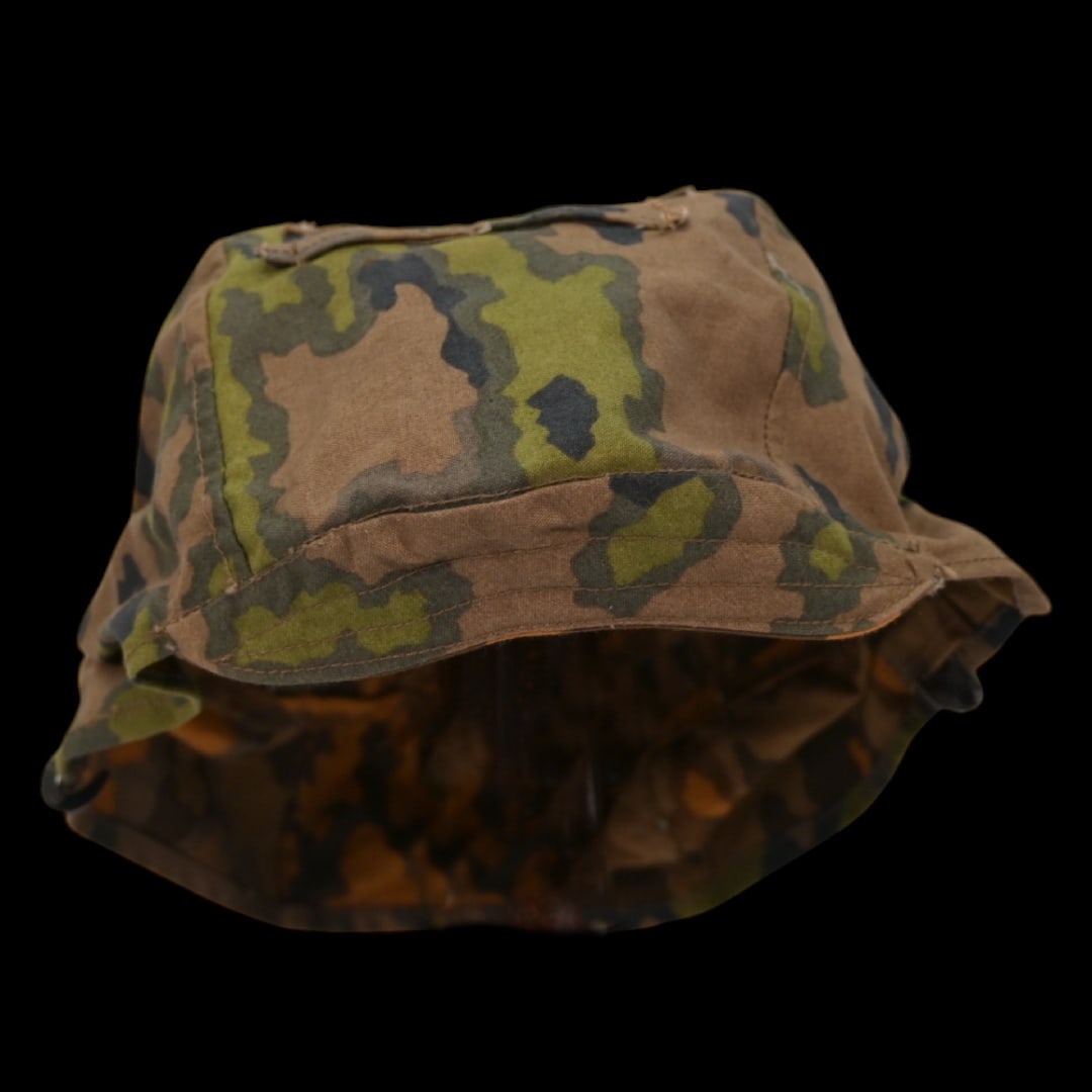 Rare WWII Nazi German cover for Waffen SS helmet, 1st type in oak leaf pattern camouflage.: Rare WWII Nazi German cover for Waffen SS helmet, 1st type in oak leaf pattern camouflage. A helmet cover 1st type in oak leaf pattern camouflage. Reversible issue in cloth imprinted with spring and a