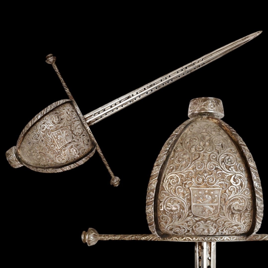 A beautiful Left-hand dagger with coat of arms, 17th century style, stamped by P. Giordano, 19th C.: A beautiful Left-hand dagger with coat of arms, 17th century style, stamped by P. Giordano, 19th century. Straight, powerful blade, with deep fullers and perforations. Guard of classical for Spanish L