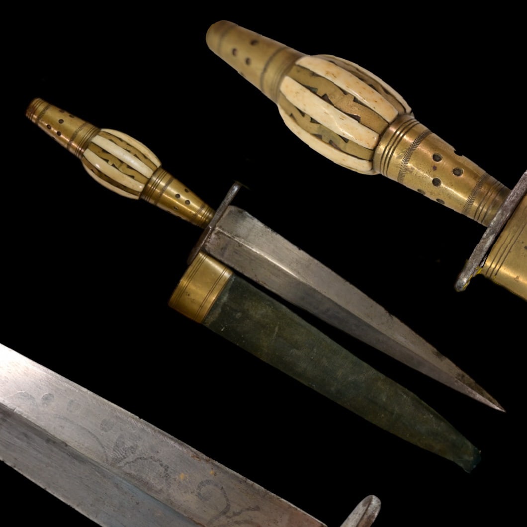A Spanish Dagger, Albacete, 19th century.: A Spanish Dagger, Albacete, 19th century. A perfect example with 15 cm. elongated leaf shaped blade, iron cross guard and barrel form bone grip flanked by conical brass mounts with geometric engraved 