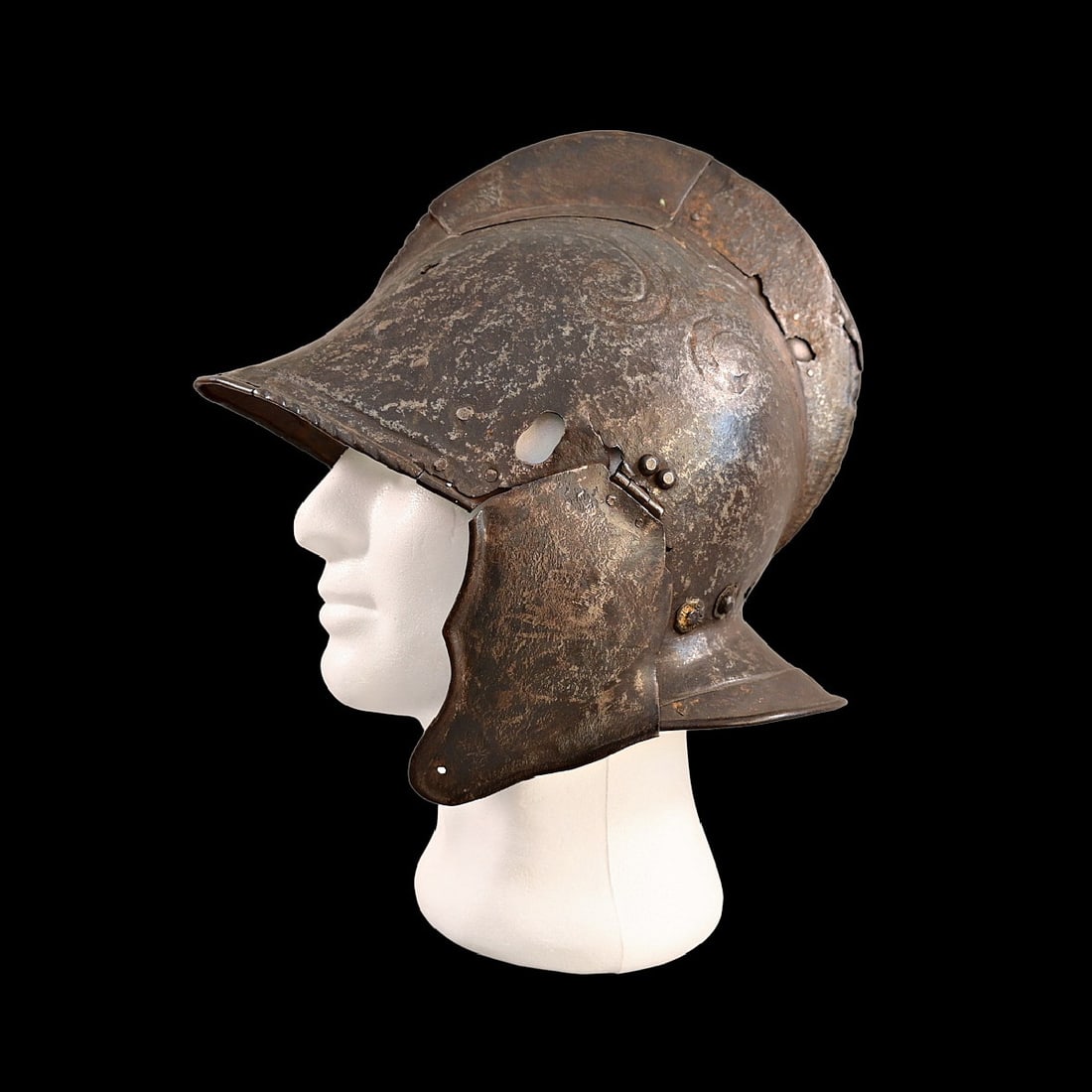 16TH CENTURY BURGONET HELMET: The burgonet helmet, Europe, 16th century. Decorated with relief pattern and remains of gilding. Restoration of the period of existence of the helmet. Probably the period of the religious war in Franc