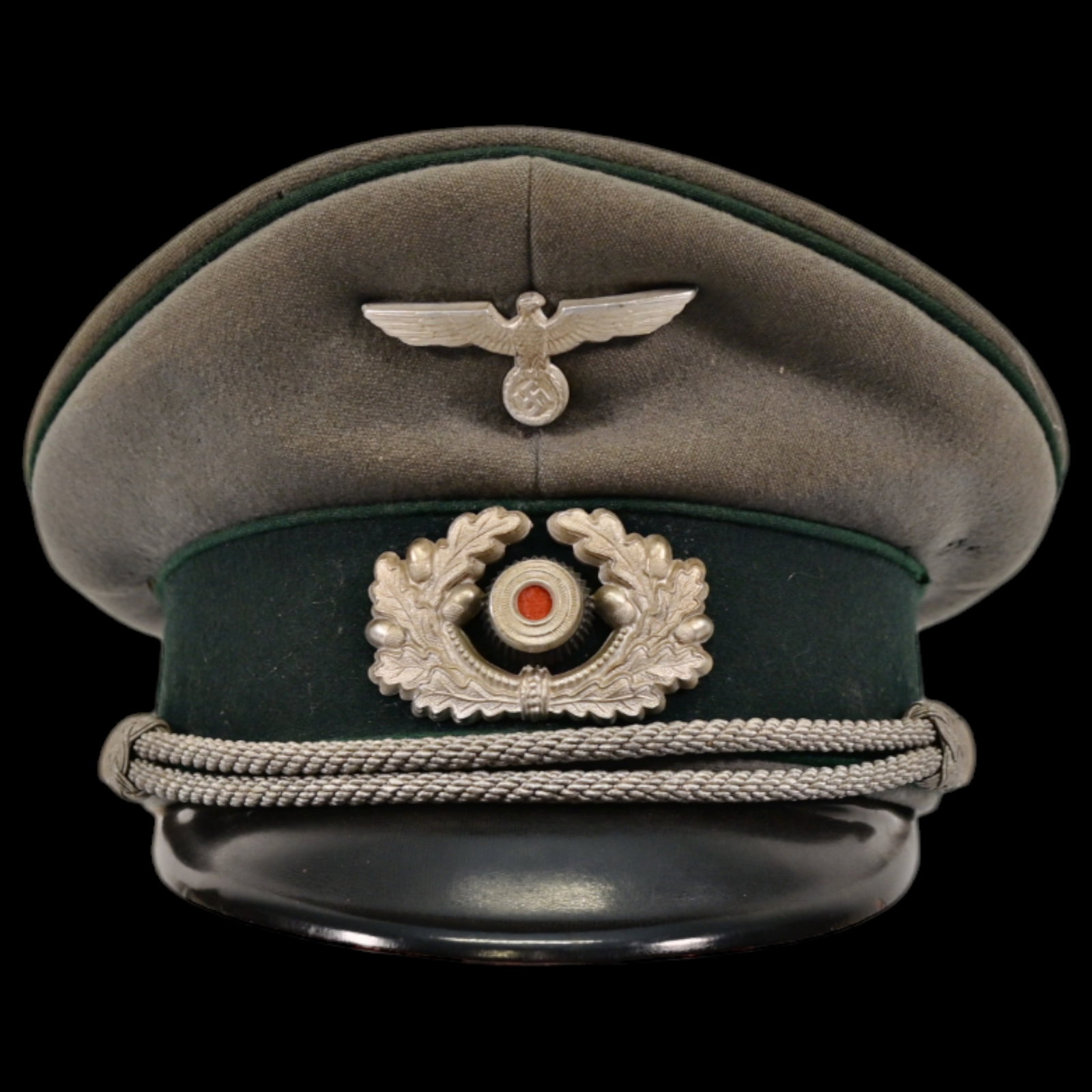WWII Nazi German Mountain Troop, JAGER, Officer visor cap, featuring the iconic eagle.: WWII Nazi German Mountain Troop, JAGER, Officer visor cap, featuring the iconic eagle and wreath insignia. This well-preserved piece includes a manufacturer's stamp on the inside. The cap reflects the