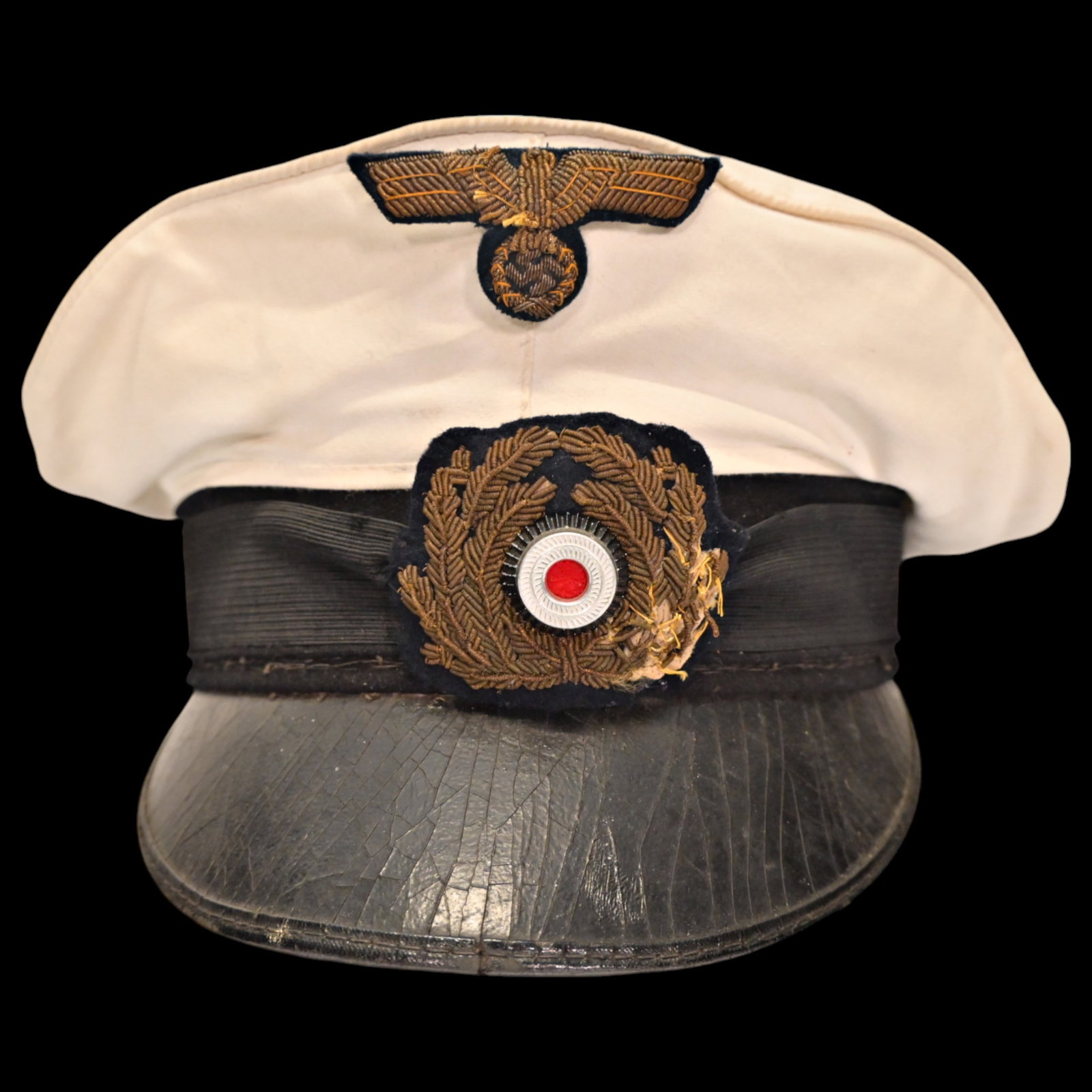 WWII Nazi German NCO of the Kriegsmarine visor cap.: WWII Nazi German NCO of the Kriegsmarine visor cap. A white visor cap for non-commissioned officers of the Kriegsmarine. Black trim band, the hand-embroidered cap wreath with metal cockade. Cap with r