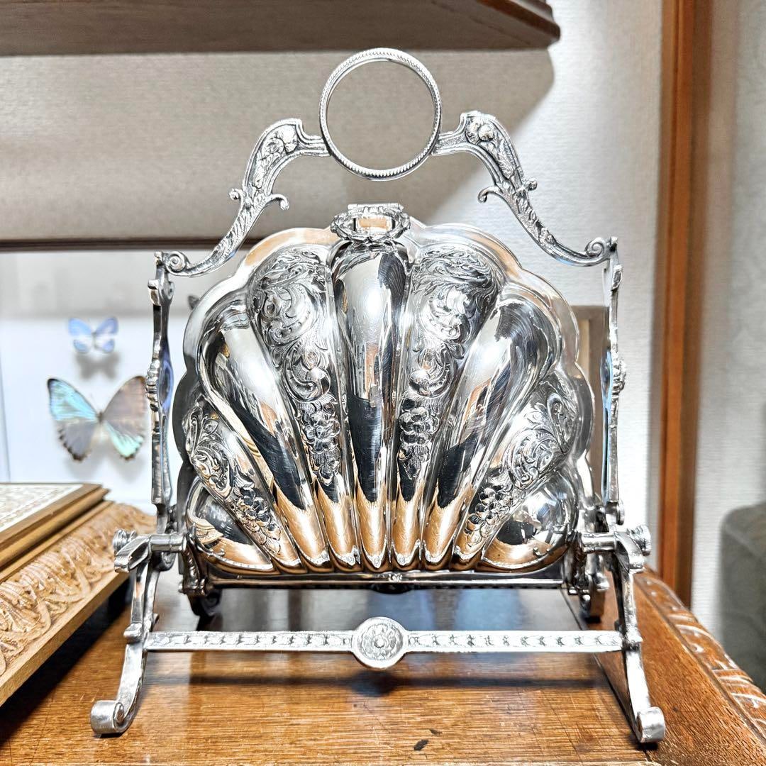 [Silver P] British Antique Biscuit Warmer: Approximately 21.8 cm wide, 27.0 cm high, and 14.8 cm deep. Beautifully decorated biscuit warmer. This Victorian invention made tea time more special by placing biscuits in teacups. In excellent condi