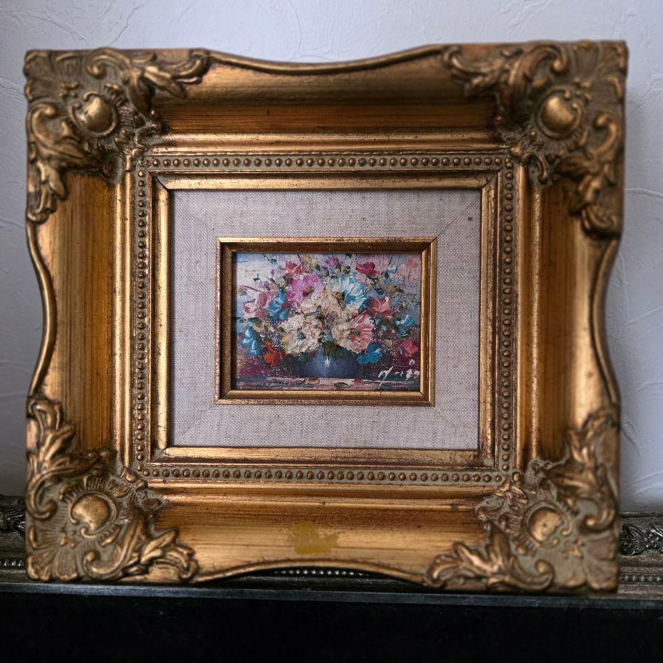 An antique oil painting depicting a bouquet of flowers, framed in a gold frame. (1 of 5)
