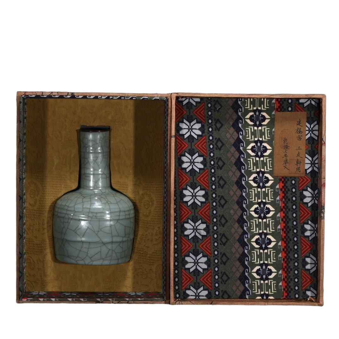 This is a poem inscribed by Emperor Qianlong on a copper-mouthed bell-shaped vessel made for the: This is a Song Dynasty official kiln copper-mouthed rattle cup, measuring 21 centimeters in height and 13 centimeters in diameter. The body of the vessel has smooth lines, a slender neck, and