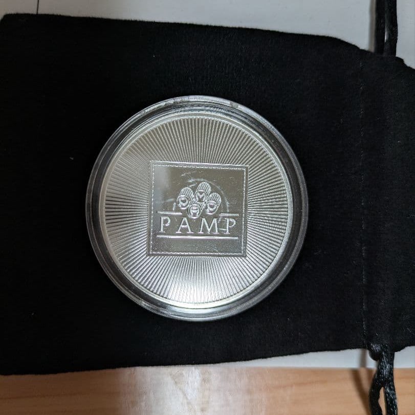 PAMP 999 pure silver 1 ounce commemorative coin (with display box): This PAMP 999 silver 1 ounce commemorative coin comes with a textured protective case. Brand: PAMP Material: 999 silver Weight: 1 ounce Design: Ribbed design Accessories: Storage box