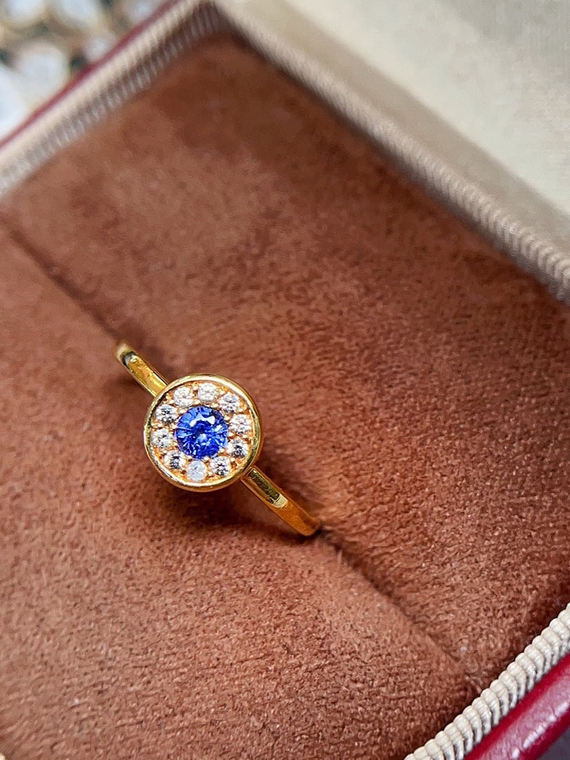 18K gold natural sapphire ring: This ring showcases a captivating natural sapphire, renowned for its cornflower blue hue and exceptional fire. The gemstone is meticulously cut into a perfect round shape, reflecting mesmerizing color