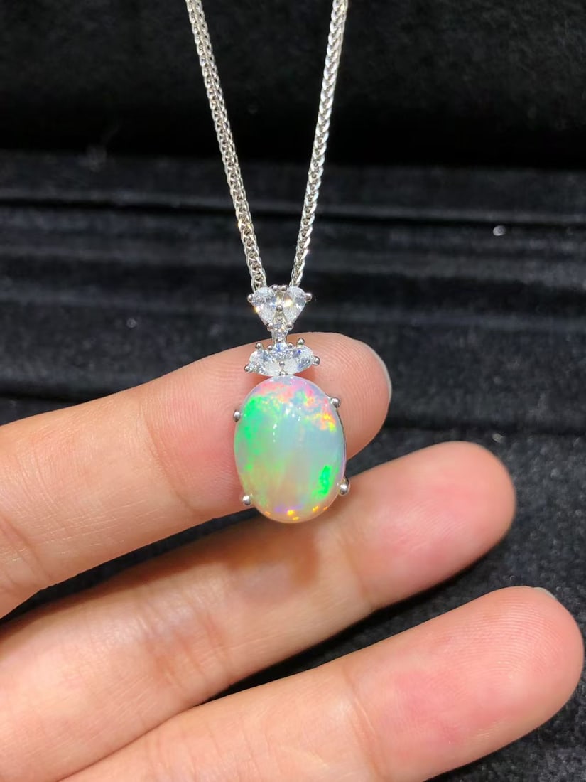925 sterling silver natural opal pendant: This pendant showcases the natural iridescence unique to opals, with the main stone measuring approximately 10x12mm. The vibrant colors of the opal are enhanced by the high-quality 925 sterling silver
