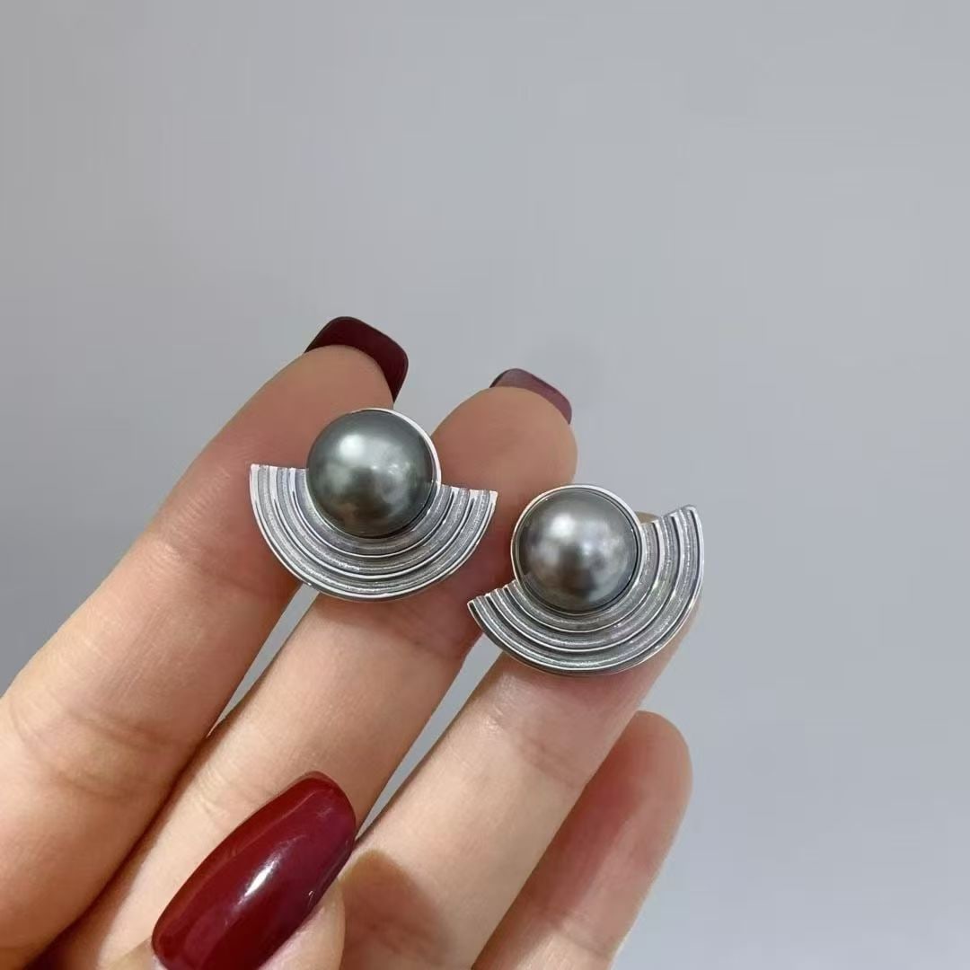 Tahitian Black Pearl Earrings 9-10mm: These earrings feature lustrous Tahitian black pearls, known for their deep, mysterious tones and exceptional luster. The pearls are expertly set in 18K gold, measuring 9-10mm, creating a bold and ele