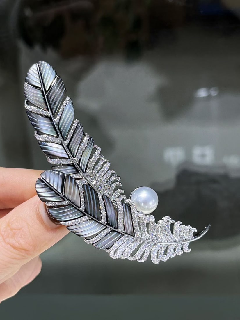 Natural sea water pearl feather-shaped brooch: This brooch is inspired by the delicate form of feathers, perfectly showcasing an elegant temperament. The natural saltwater pearl measures approximately 9-10mm, with a captivating luster. Exquisite c