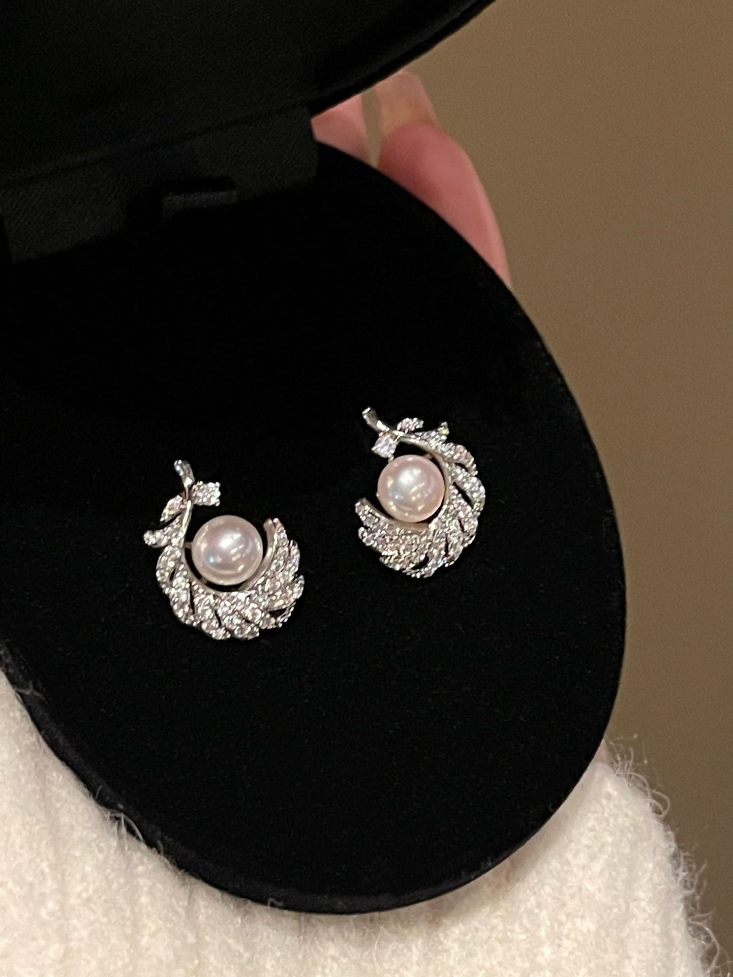 Natural freshwater pearl earrings: These earrings are delicately crafted with feather-like lines, presenting a natural and flowing design style. The earrings are set with natural freshwater pearls of around 7mm, emitting a soft