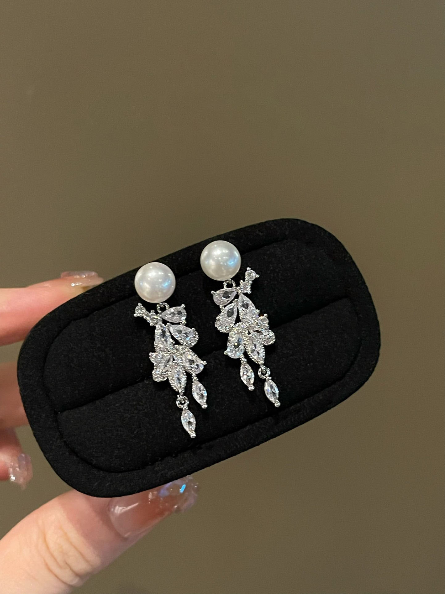 Pearl earrings: This exquisite pair of earrings showcases the timeless beauty of natural freshwater pearls, with a diameter of 8-9mm. The luster of the pearls complements the custom-cut cubic zirconia perfectly,