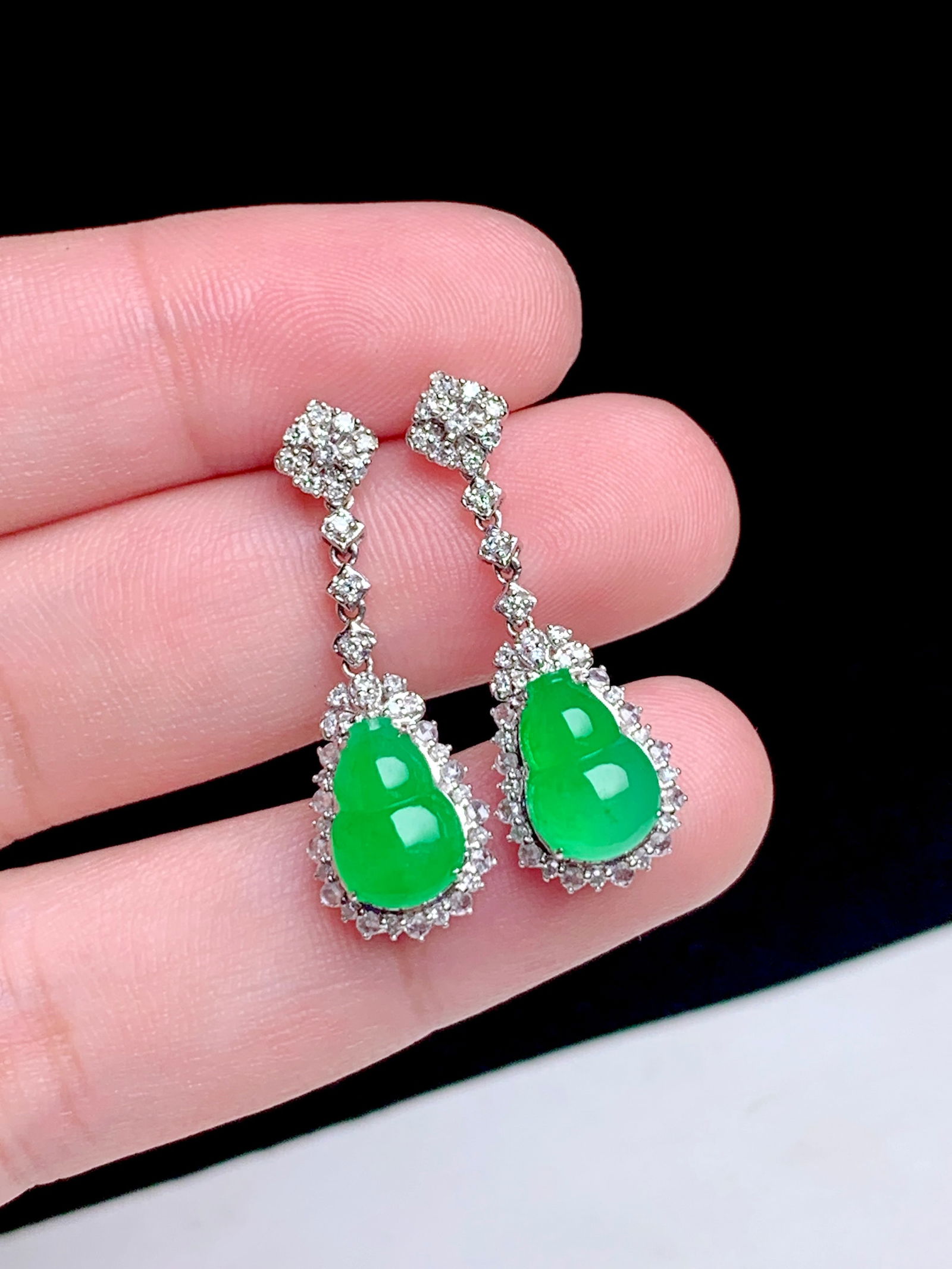 18K gold diamond inlaid natural jadeite earrings: These earrings showcase the enchanting beauty of Ice Yang green jadeite, meticulously carved into a gourd shape symbolizing prosperity and good luck. The smooth surface of the jadeite blends perfectly