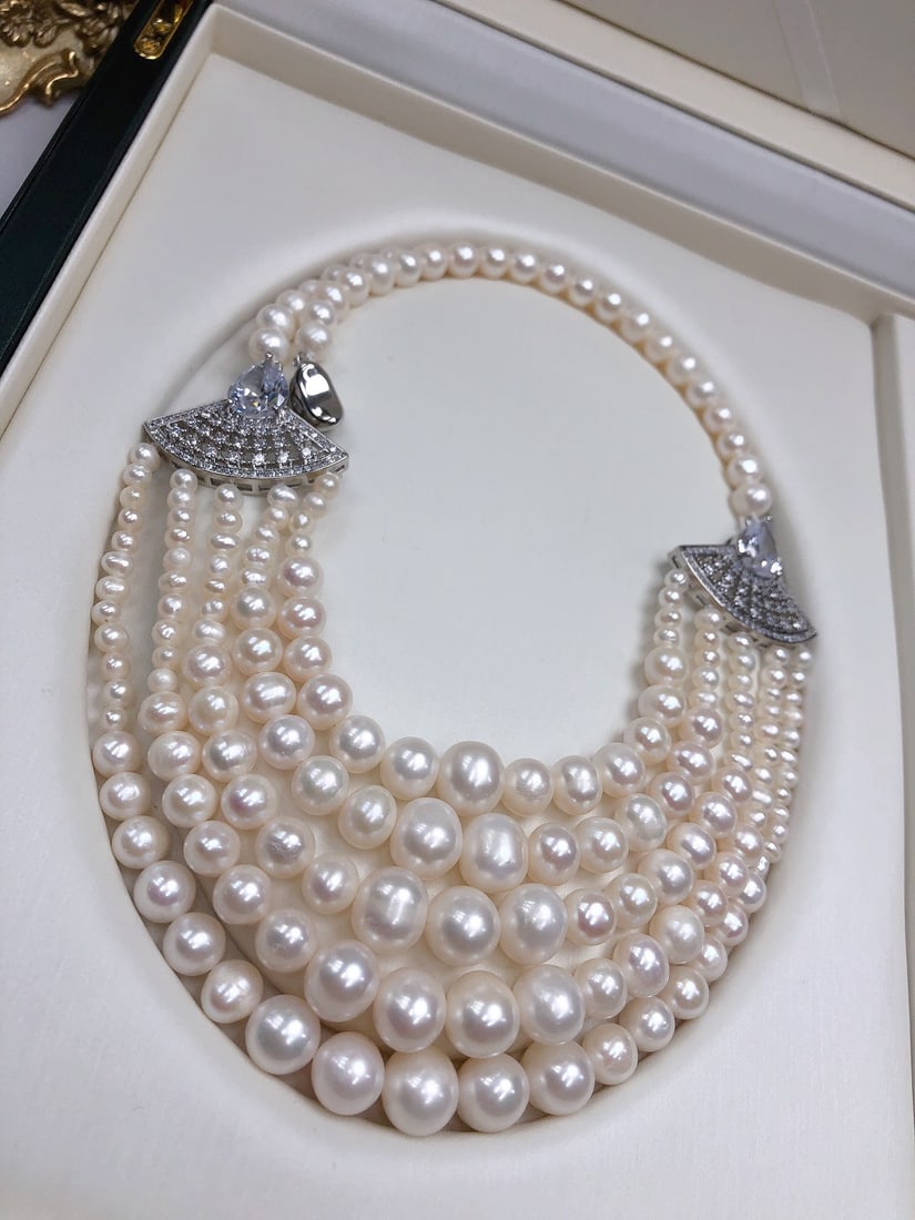 Plated Natural Pearl Necklace: This exquisite necklace perfectly combines intellect and elegance, presenting layers of lustrous natural pearls. From small to larger pearls, they elegantly complement the 18k gold-plated fan-shaped m