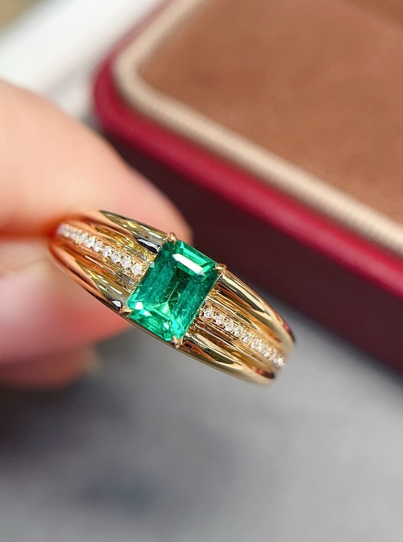 18k Gold Emerald Ring: This 18k gold emerald ring captivates with its glass-like clarity and almost perfect beauty. The fresh green hue of the emerald is bright and pleasing to the eye, making it a stunning focal point. Sur