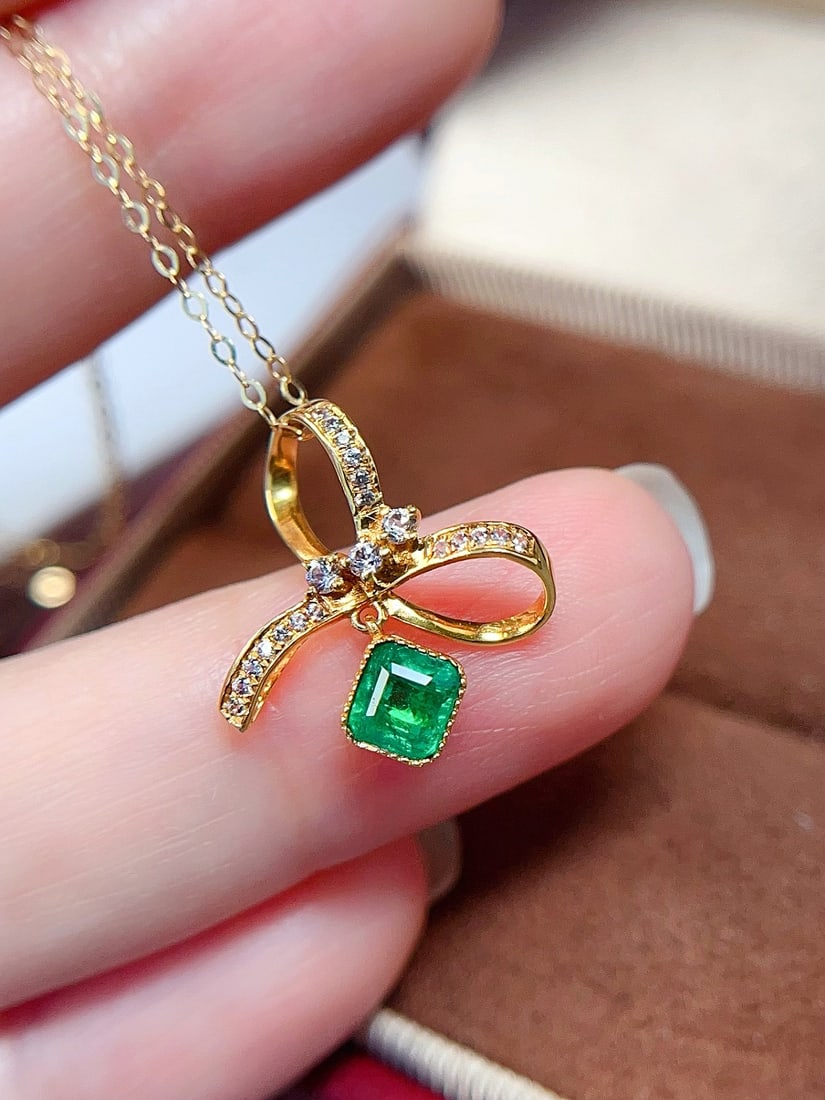 18k gold emerald pendant: This exquisite pendant captures the essence of elegance with its vibrant emerald center stone. The rich green of the emerald evokes a lush forest, perfectly complementing the dazzling brilliance of
