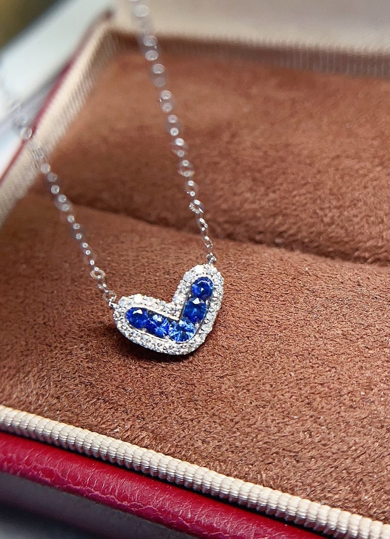 18k Gold Sapphire Necklace: This exquisite collar necklace features an 18k gold base, perfectly showcasing the elegant essence of a vivid sapphire. The heart-shaped cluster design sparkles with dazzling light, captivating with