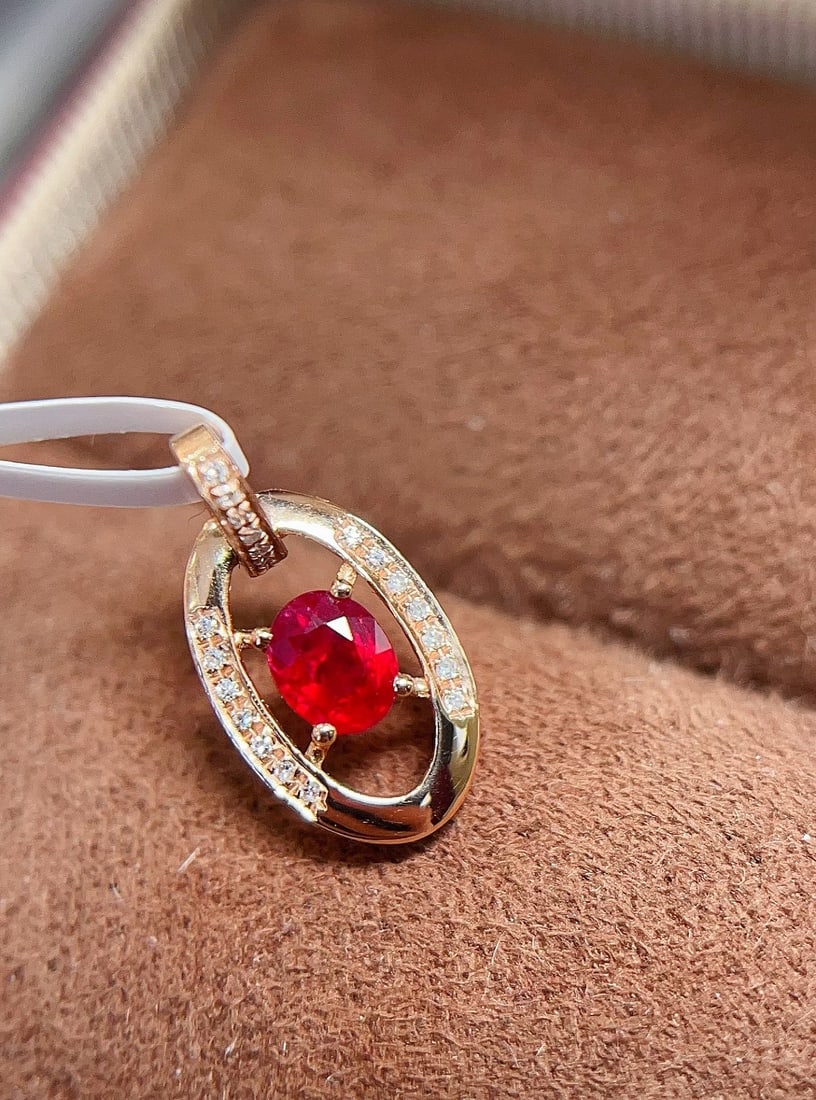 18k Gold Ruby Pendant: This pendant captures the essence of elegance with its exquisite minimalist style. At its center is a stunning pigeon blood red ruby, captivating the soul with its intense color. Surrounding this
