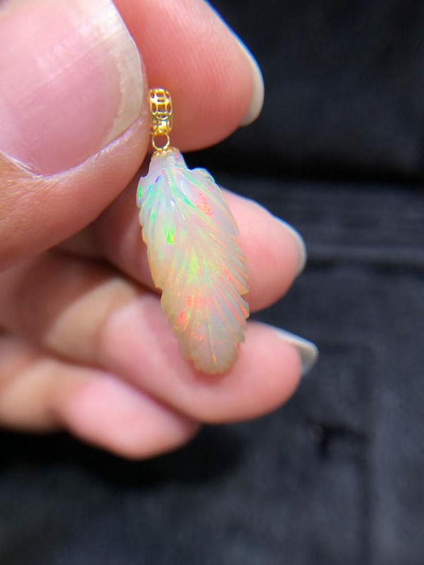 18K gold opal pendant: This pendant is based on 18K gold, exquisitely inlaid with dazzling opal, showcasing unique color changes and charming luster. The hand-carved leaf pattern adds a touch of natural elegance, perfectly