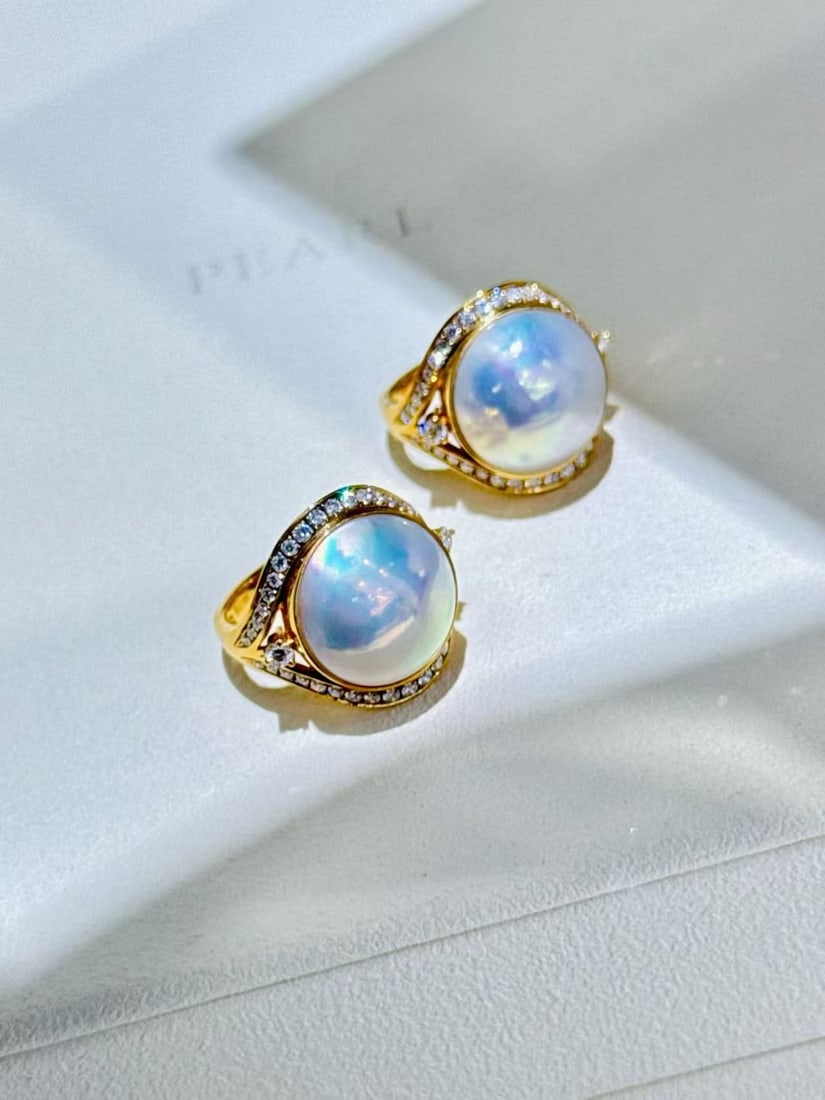18K gold blue sapphire earrings: These earrings feature a core of blue horse conch pearls, displaying a unique soft light, like a romantic poem by the ear. The pearl's naked bead has a diameter of 13 millimeters, with a hint of caram