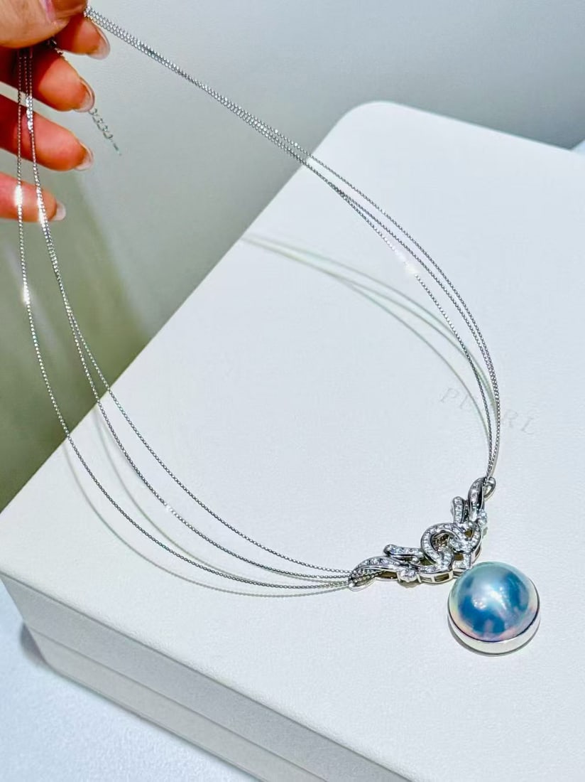 18K white gold blue mabe pearl necklace: This collar is meticulously crafted with 18K white gold, paired with the dazzling blue abalone pearl, resembling the deep blue of the night sky that captivates at first sight. The pearl's mirror-like