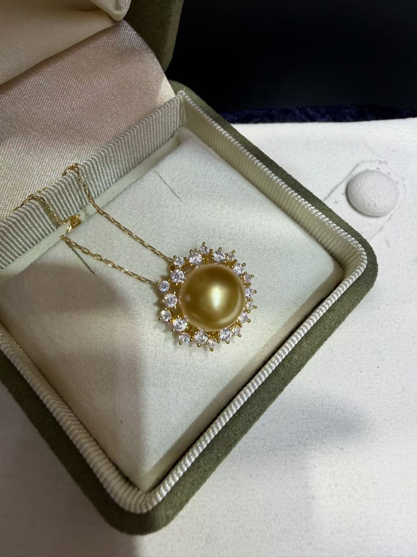 Golden South Sea Pearl Pendant: This pendant features a 11-12mm golden South Sea pearl at its center, presenting an almost perfect round shape. The golden pearl has a rich color and is flawless, as if it embodies the essence and