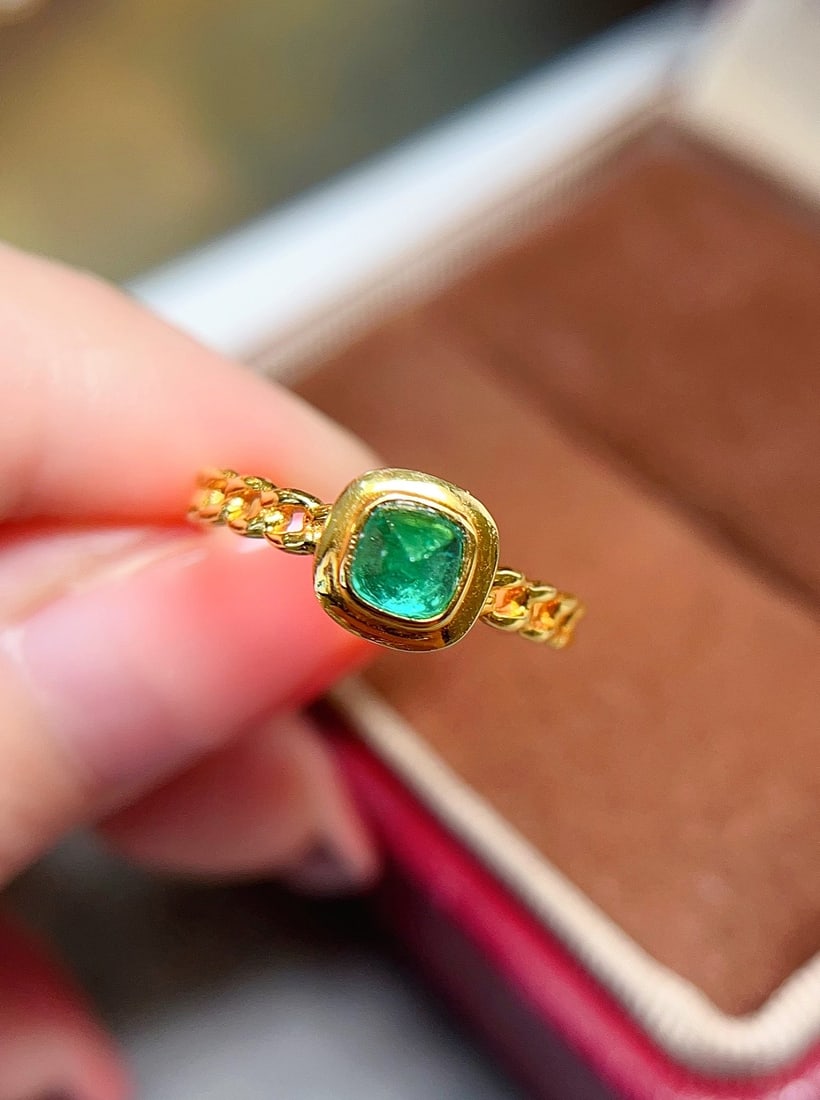18K gold emerald ring: This 18K gold emerald ring showcases a rich and captivating luster with its unique spicy green sugarloaf hue. The emerald's dryness without cracks and its fluorescence properties allow it to emit a