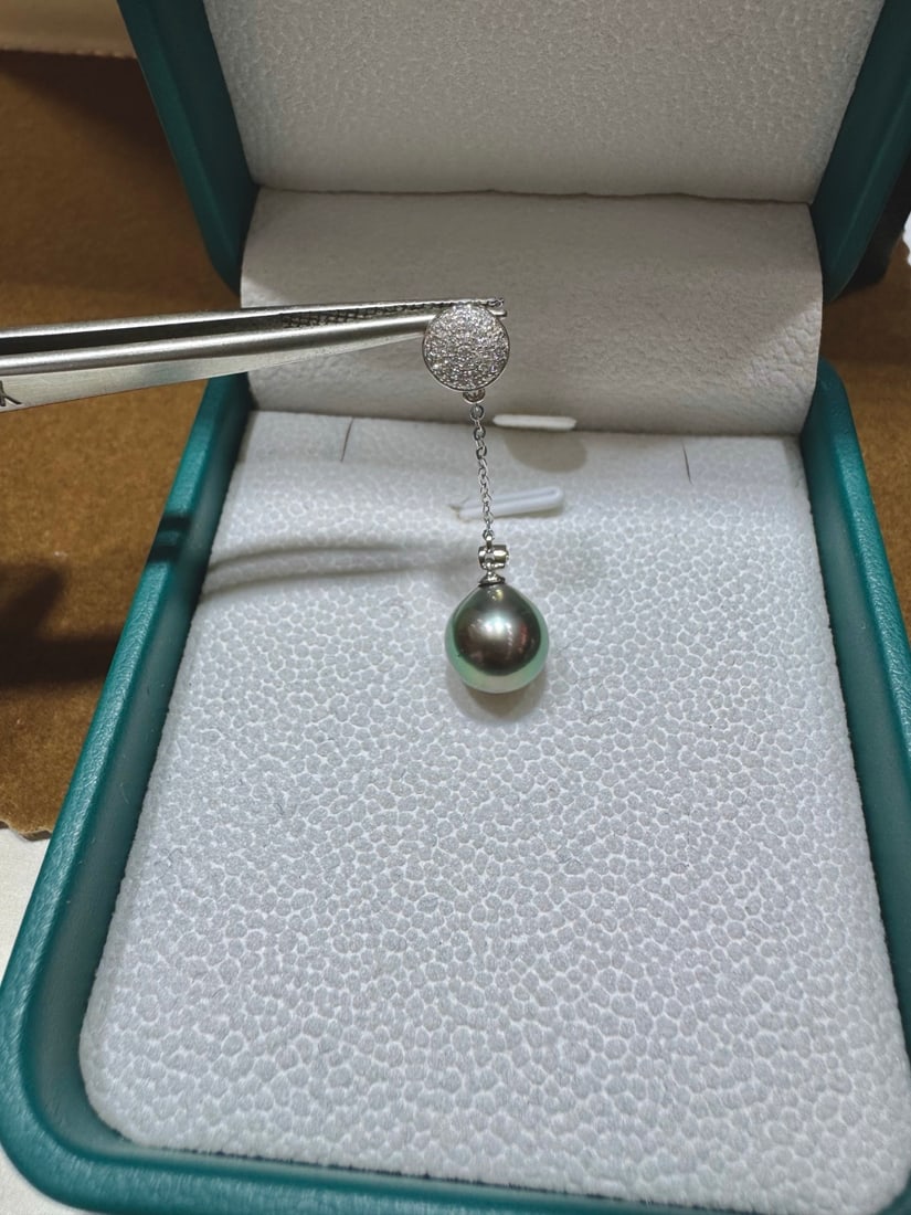 18K gold zirconia Tahitian black pearl pendant: This 18K gold zirconia Tahitian black pearl pendant shines like the stars in the night sky, emitting a mysterious and captivating light. The strong luster of the black pearl complements its subtle