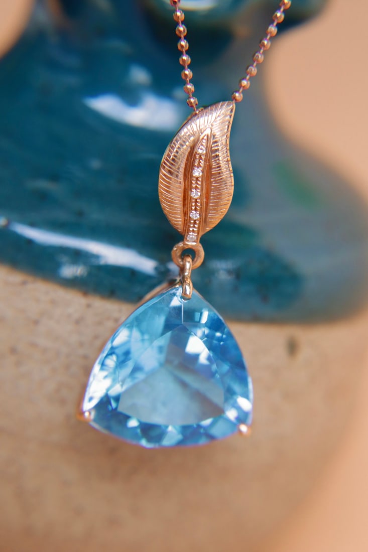 18K Gold Topaz Pendant: This 18K gold topaz pendant is a captivating treasure, perfectly showcasing the combination of elegance and luxury. The topaz, with its weight of 12.65 carats, emits a charming radiance, like a fresh