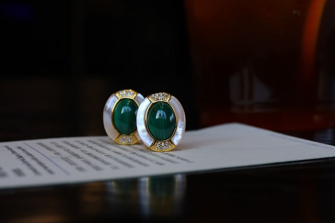 Peacock ore earrings: This pair of ear clips features natural peacock stone as the main stone, showcasing a rich green elegant color, charming like peacock feathers. Paired with natural white mother-of-pearl, it presents