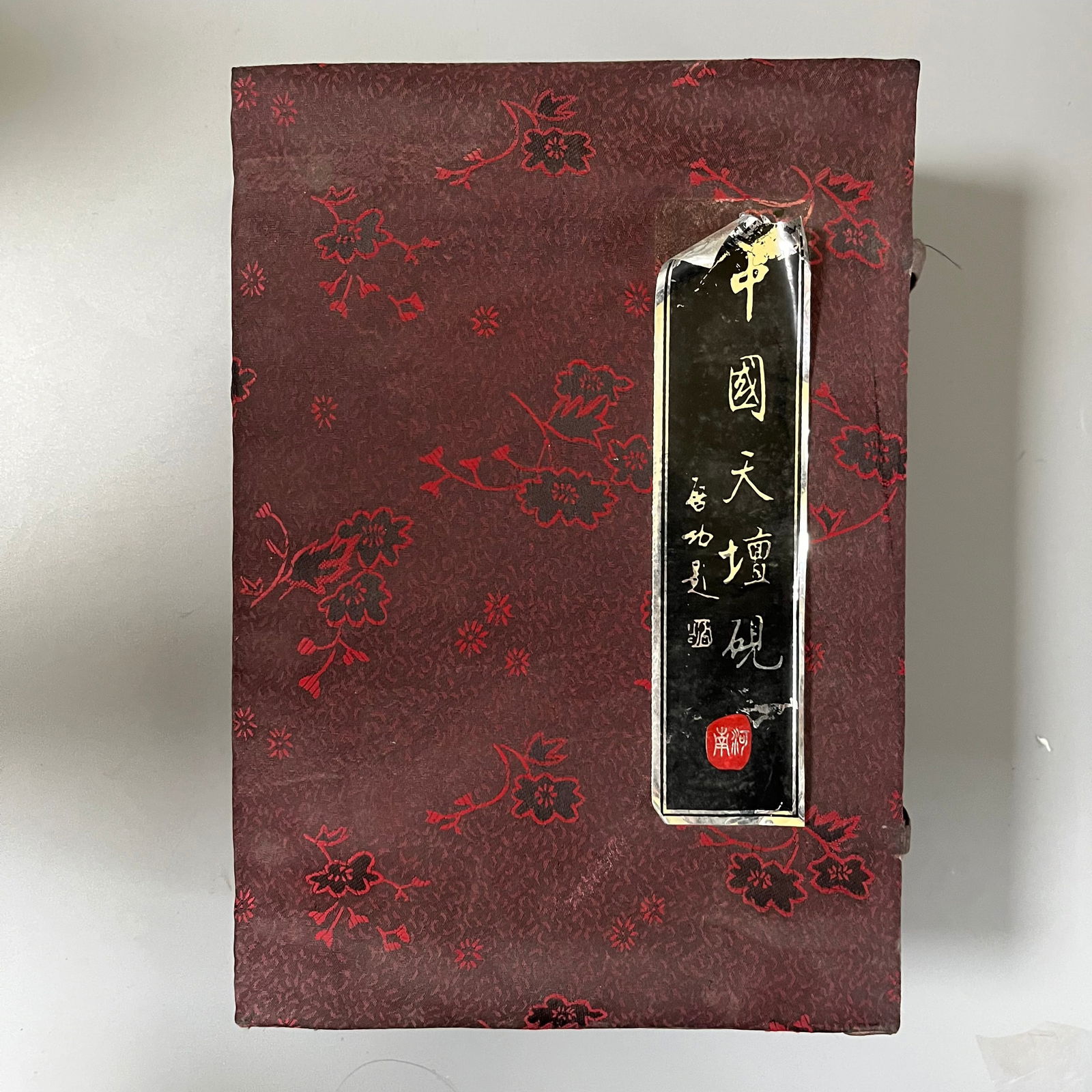 Tian Tan Inkstone: Tian Tan Inkstone, 18x11x2 cm.The inkstone's main body is naturally shaped, with a deep brown color and a smooth, jade-like surface. The upper right corner features a relief carving of a mythical