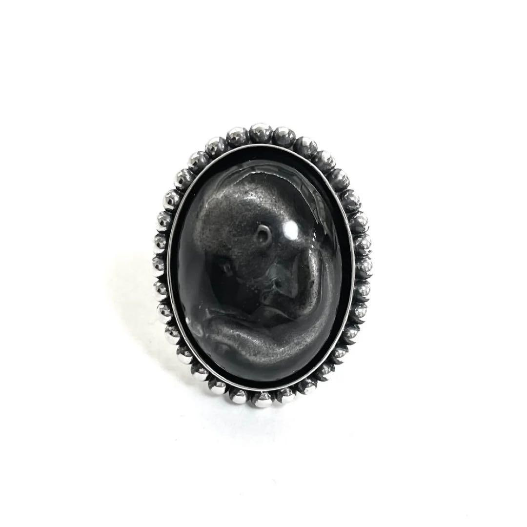 (Second-hand) Madaraningen ring, size 17: Material: 925 silver Available sizes: 5, 7.9, 11, 14, 17, 20, 23 Top: Approximately 30mm in length, 23mm in width A striking design featuring a fetus placed inside a dome. The back is engraved with a