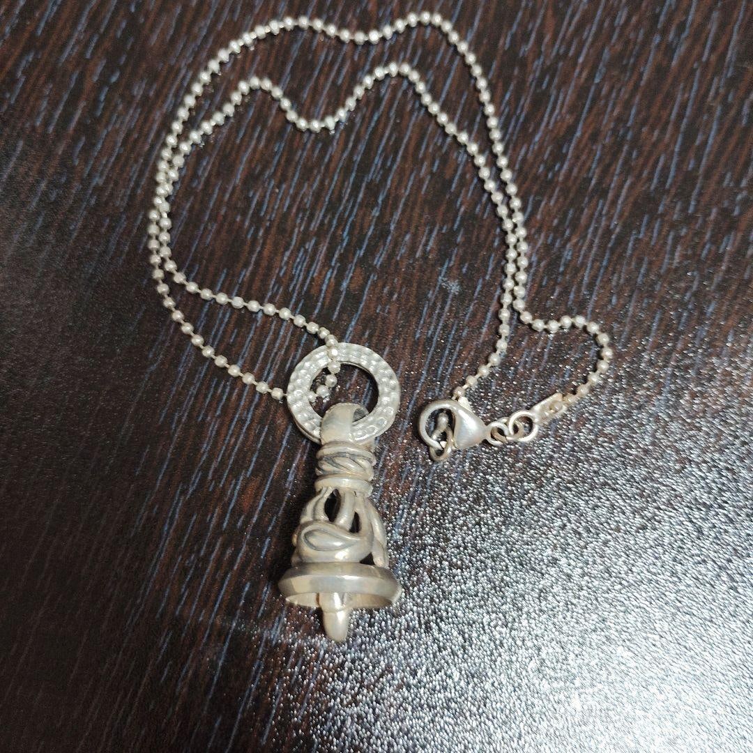 (Second-hand) Silver Bell Pendant Necklace: A silver bell-shaped pendant necklace with a pattern engraved on it. Material: Silver Design: Bell-shaped pendant Chain type: Ball chain Closure: Lobster clasp Decoration: Engraved pattern
