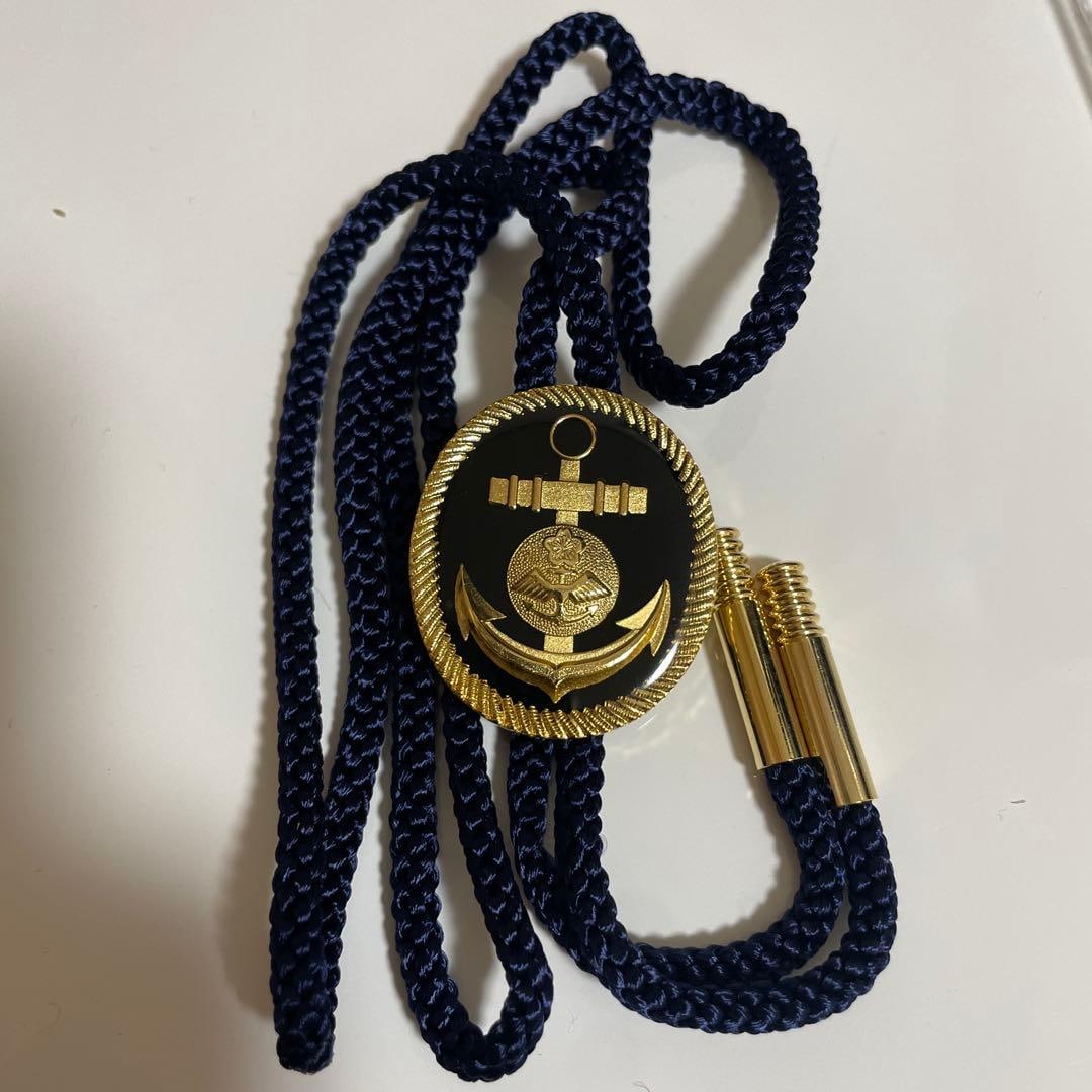 (Second-hand) Yokaren gold circle tie, with anchor-shaped decoration: Navy blue synthetic fiber circular tie with anchor pattern. Color: Navy blue Material: Synthetic fiber Design: Anchor and medal decoration Buckle material: Metal Buckle shape: Oval