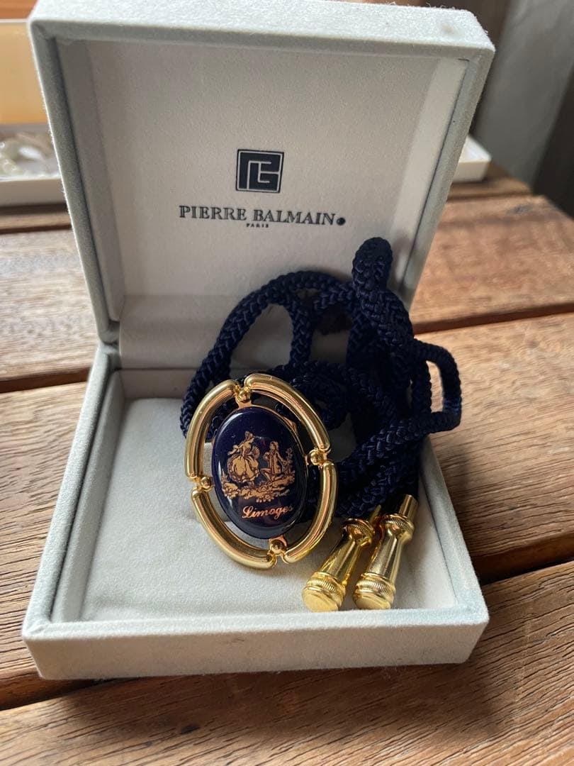 (Second-hand) PIERRE BALMAIN Navy Blue Circular Collar Tie: This circular necktie is made of navy blue nylon rope, adorned with gold accents and a Limoges pattern. Brand: Pierre Balmain Color: Navy blue Decoration: Oval pendant with gold accents Design: