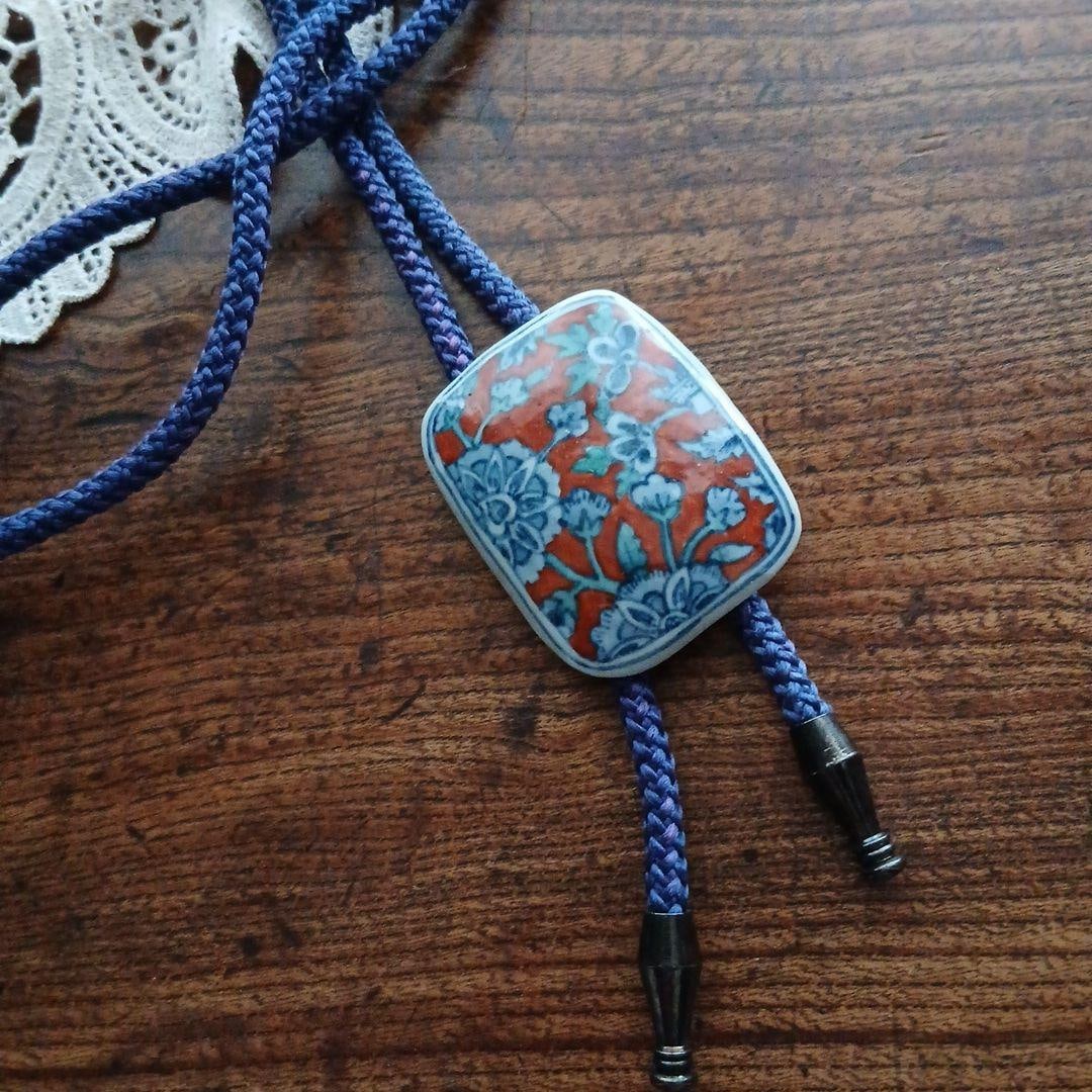 (Second-hand) Yokohara Yohei Ceramic Floral Design Circular Tie Necklace Vintage: Iwadate Yohei Circular Tie Necklace This is a circular tie necklace with a floral pattern. No packaging box or accessories included. The back is inscribed with "Yo".