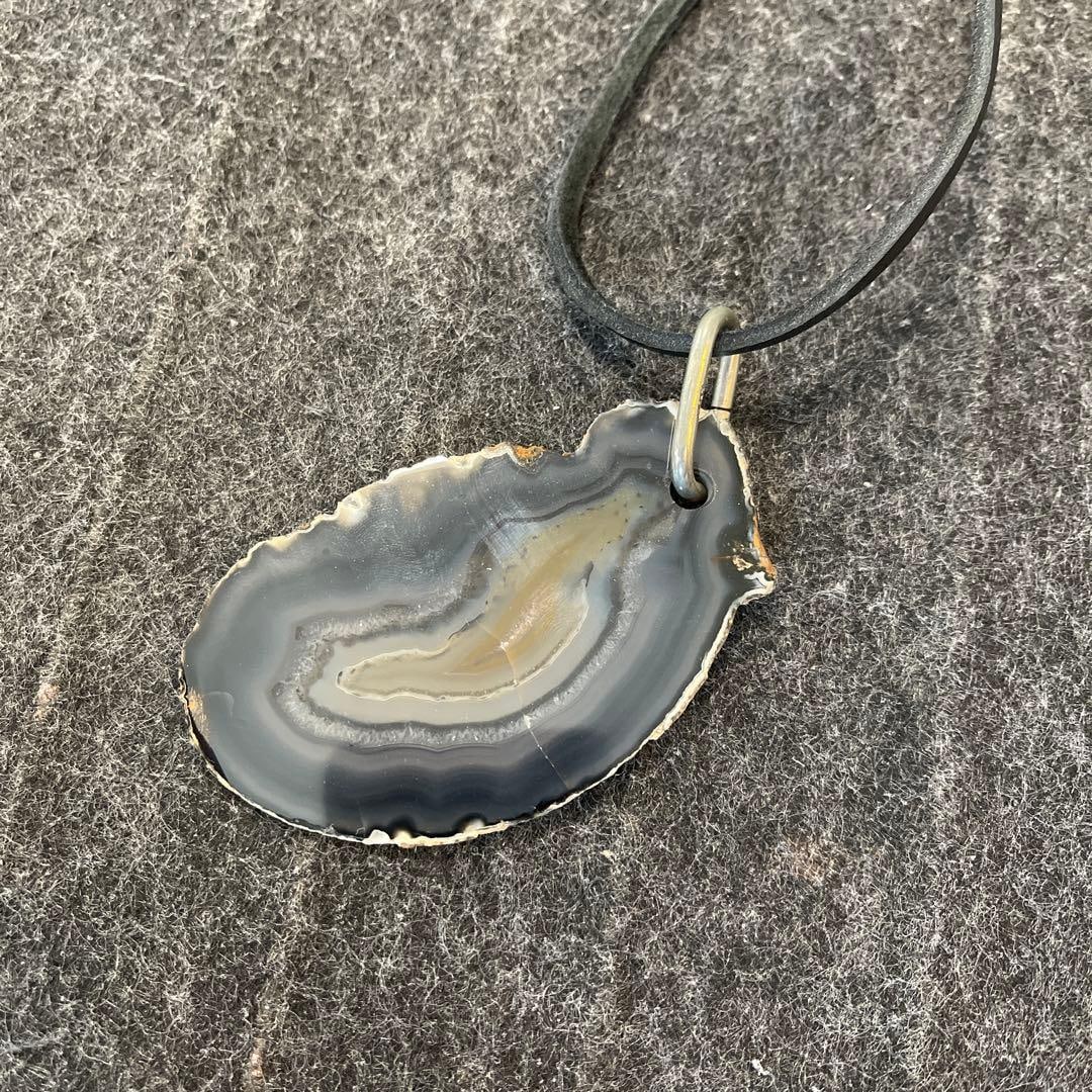(Second-hand) Gray pendant necklace: Gray agate pendant necklace, with adjustable leather chain. Material: Agate Color: Gray Design: Pendant Chain material: Leather Shape: Irregular shape Length: Adjustable