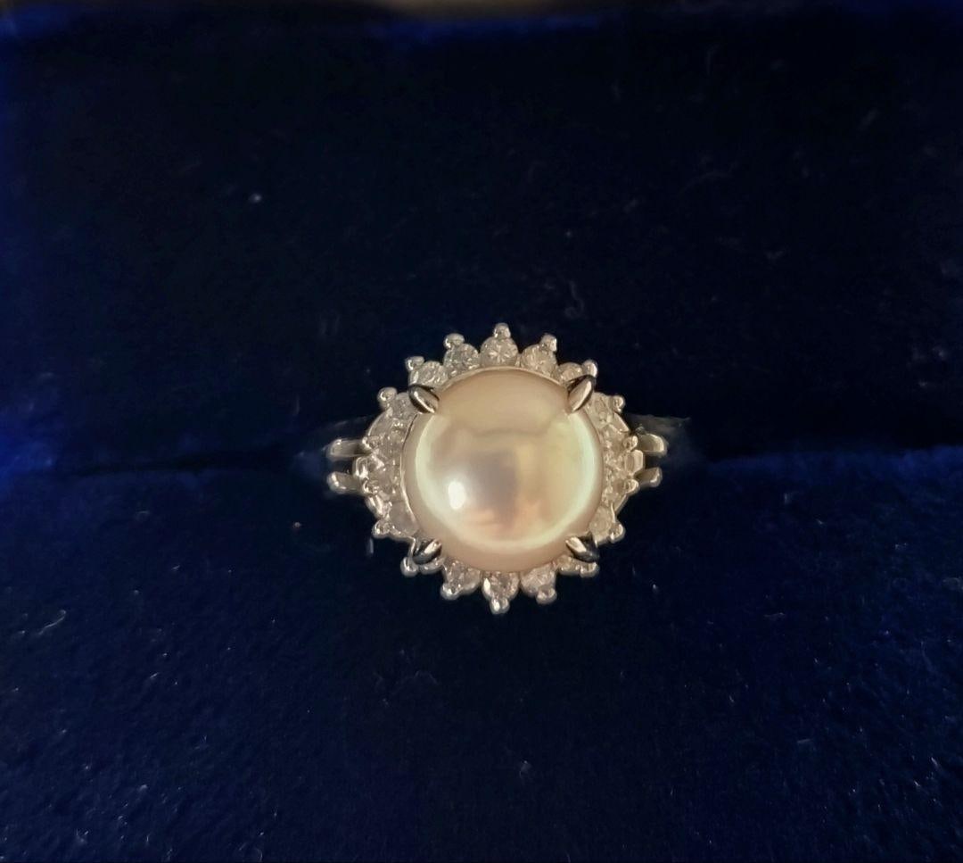 (Second-hand) Pearl Ring: Pearl Ring Pearl size is 6.7 millimeters. Color is slightly pink with very good luster, surrounded by diamonds. The diamonds are engraved with the number 0.23. pt850 Size 11