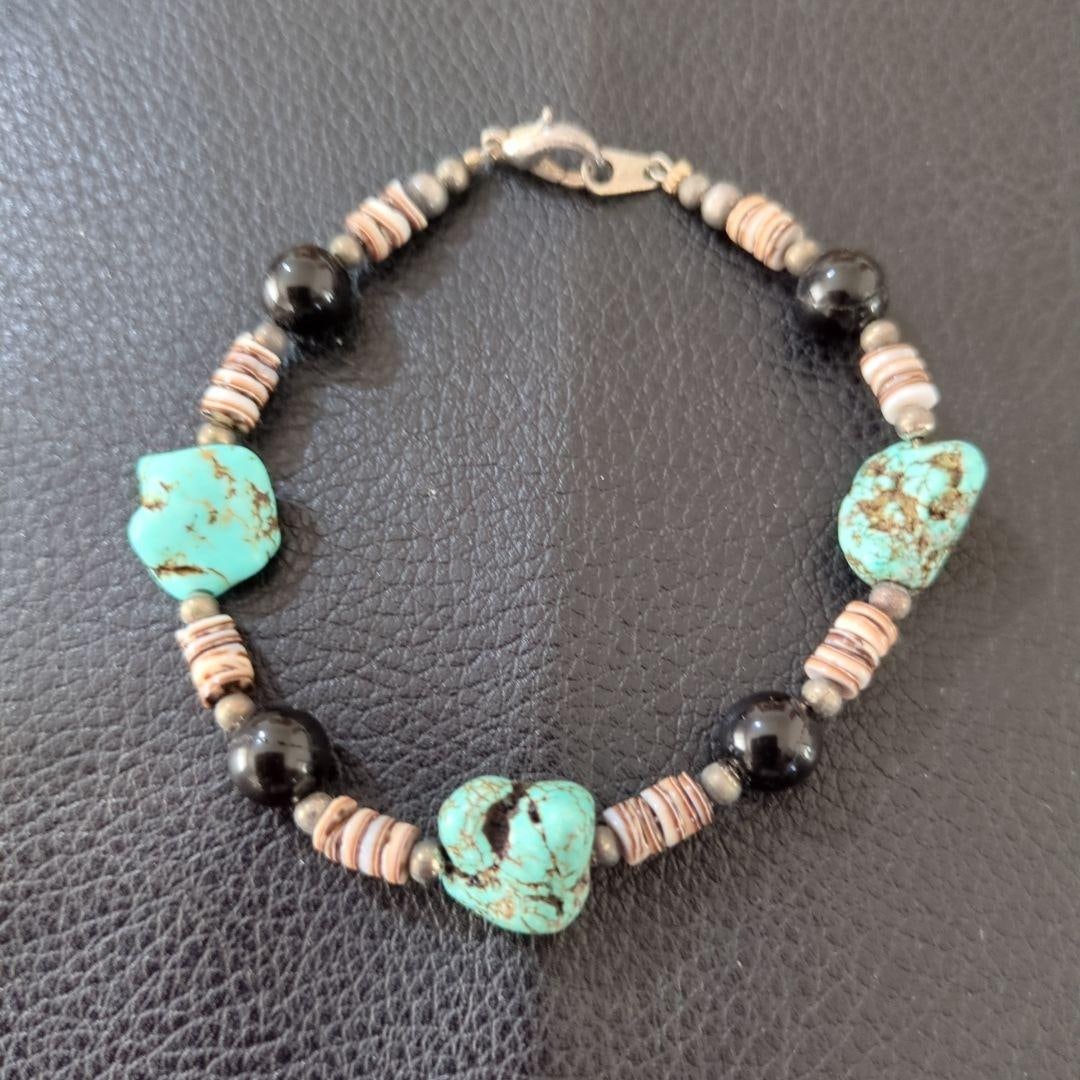 (Second-hand) Turquoise and Obsidian Bracelet: A casual bracelet made of turquoise and obsidian (material unknown). Dimensions Diameter: 7 cm Materials: Turquoise, obsidian, beads Style: Casual Colors: Turquoise, black, beige