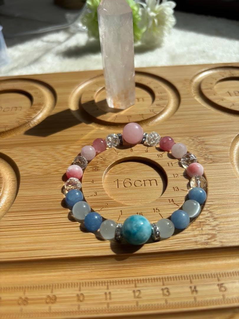 (Second-hand) Natural Stone Bracelet: This elegant and magnificent natural stone bracelet seamlessly blends the gentle blue of the sea with delicate pink hues. At its center is a Larimar stone (12mm), reminiscent of a calm ocean, flanked