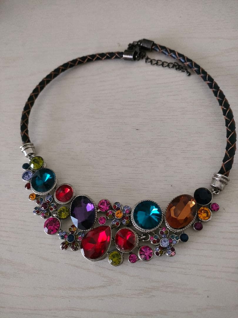 (Second-hand) Purple Rhinestone Leather Necklace: Leather cord necklace with colorful gemstone embellishments. Artificial jewelry. Durable metal fittings prevent discoloration. Purple version is sold out. Dimensions of decorative part: 3 x 11 cm