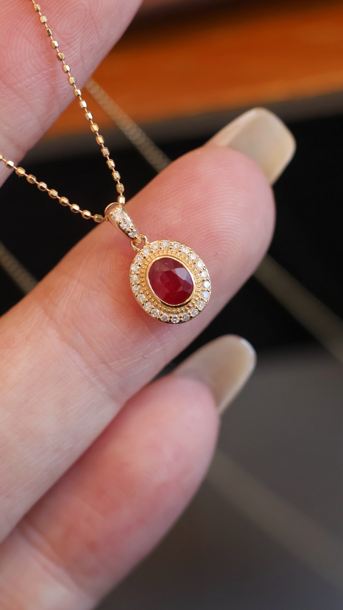 18K Gold Ruby Diamond Pendant: This pendant captures the fiery passion of a ruby with its pigeon blood red hue, reminiscent of a blazing flame. The surrounding diamonds glimmer like starlight, creating an ethereal halo that evokes