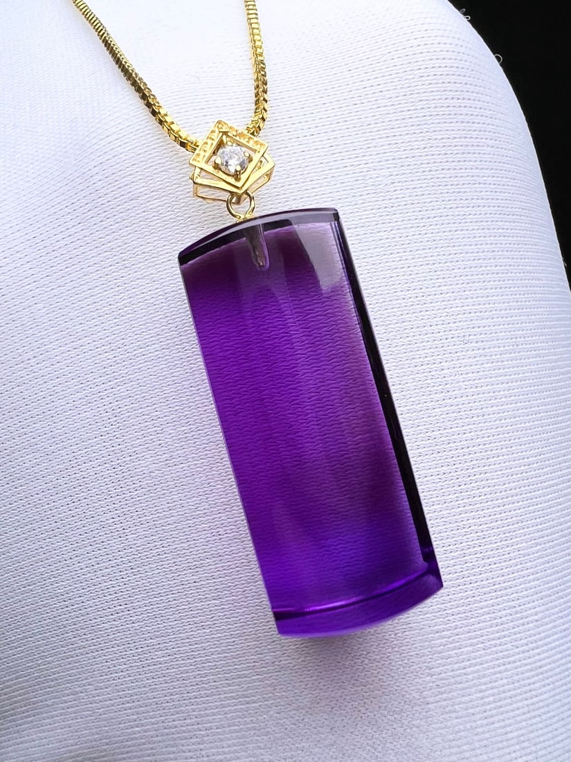 18K Gold Amethyst Pendant: This 18K Gold Amethyst Pendant is a captivating piece that exudes elegance and sophistication. The pendant features a simple yet grand design, with a crystal-clear amethyst that showcases an absolutel