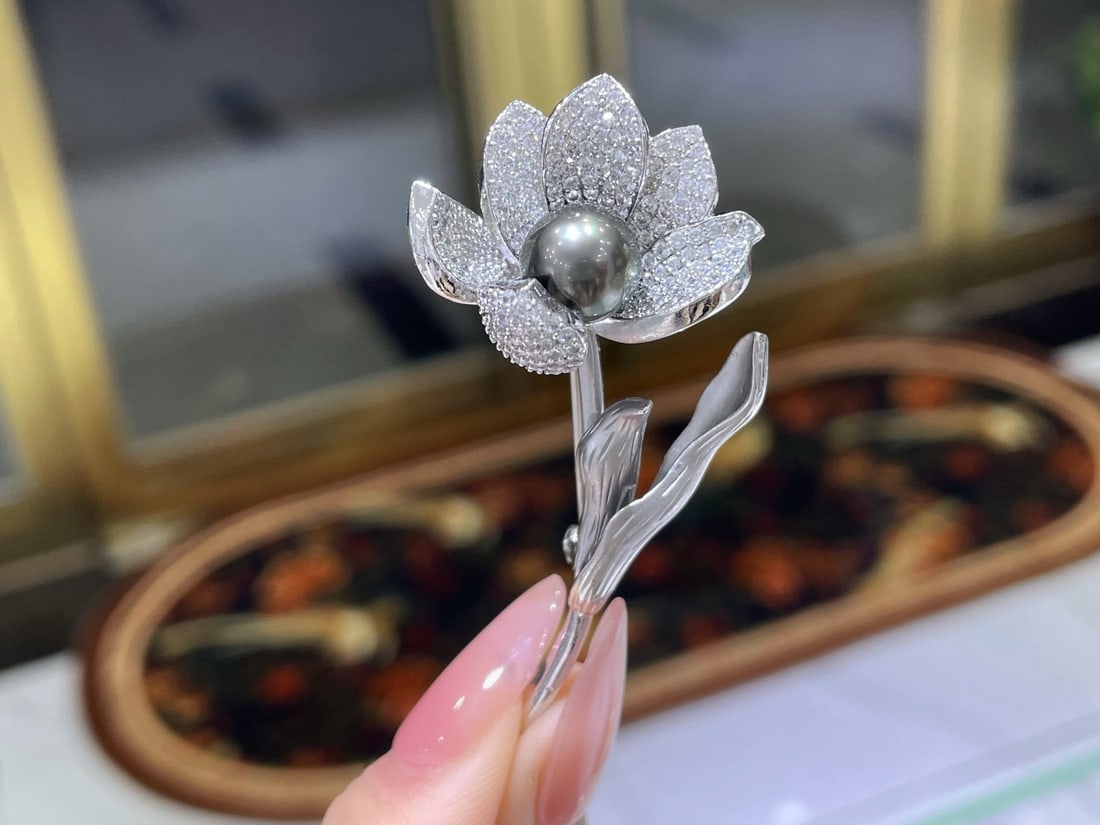 Tahitian Pearl Brooch: This exquisite brooch features a mesmerizing Tahitian pearl, celebrated for its natural allure and sophisticated charm. The pearl, ranging from 8 to 9mm, exudes a deep, captivating luster that