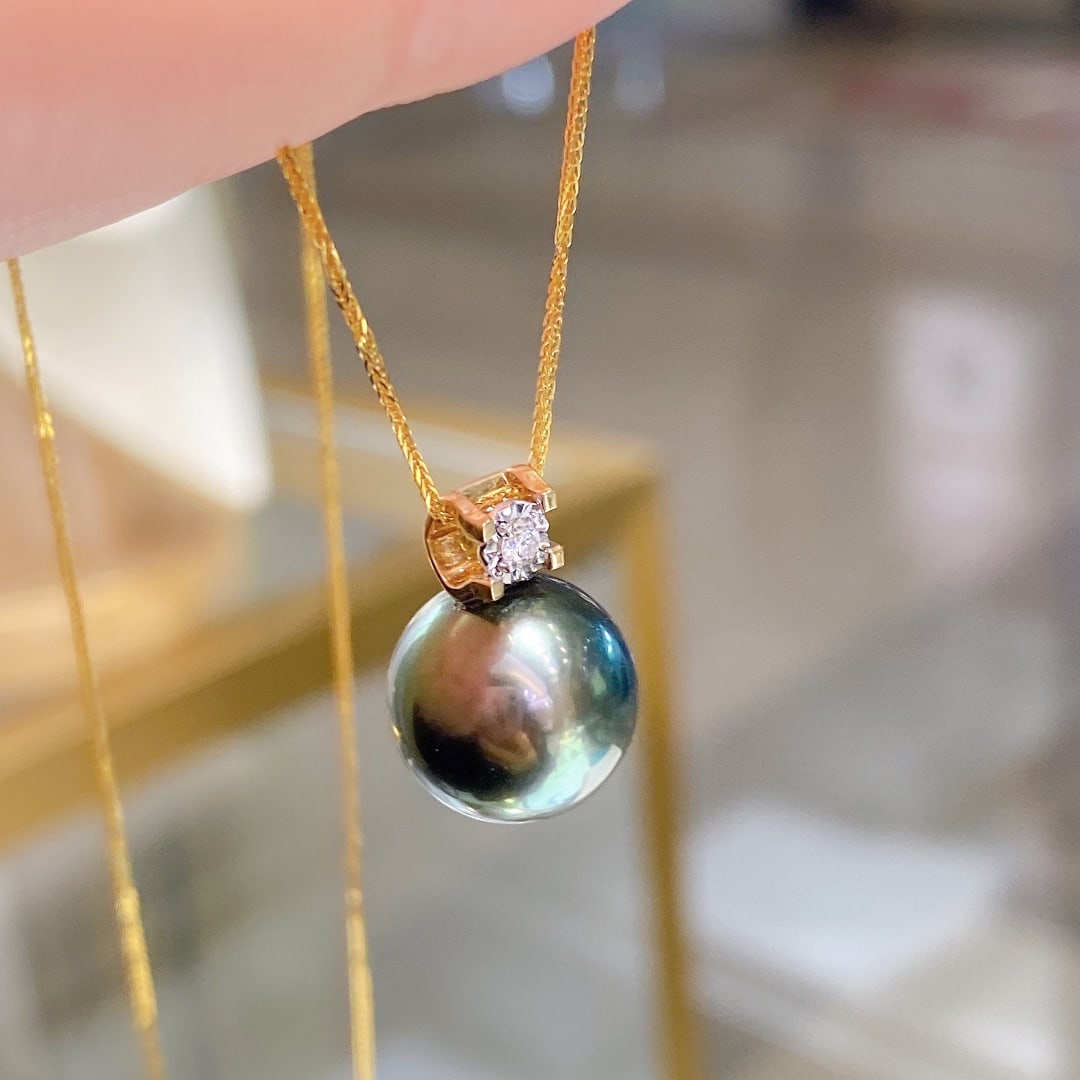 18K Gold Tahitian Pearl Pendant: This 18K Gold Tahitian Pearl Pendant is the epitome of elegance and luxury. Crafted with exquisite precision, it features a stunning natural black pearl with a flawless surface and exceptional luster.