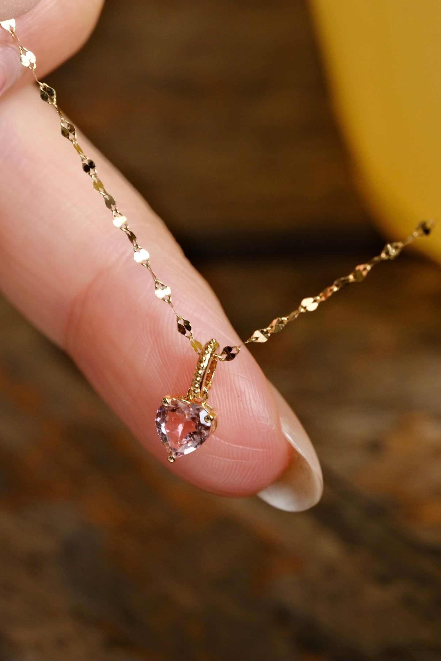 18K Gold Tourmaline Pendant: This 18K Gold Tourmaline Pendant captures the essence of elegance and charm with its natural heart-shaped tourmaline, delicately set in a three-prong gold setting. The pendant's design is adorned