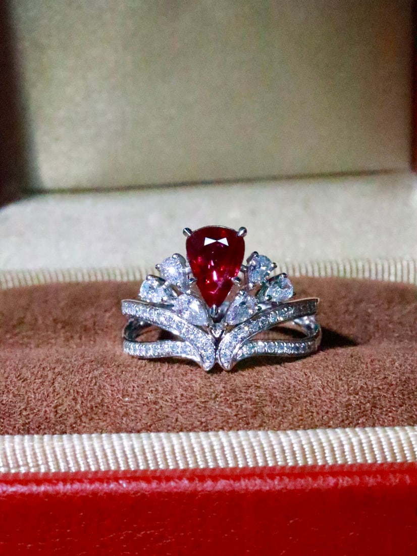 Platinum Ruby Ring: This exquisite platinum ruby ring is a true testament to vintage romance and regal allure. The crown-inspired design radiates an undeniable aura of elegance and sophistication. The centerpiece is a ca